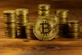 Golden bitcoin and stacks of coins on wooden background Royalty Free Stock Photo