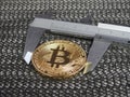 Golden Bitcoin and vernier caliper. Royalty Free Stock Photo