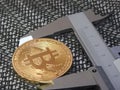 Golden Bitcoin and vernier caliper. Royalty Free Stock Photo