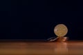 Golden Bitcoin on wooden floor. Gold digital coin on pile of coins with black background