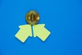 Golden bitcoin with yellow paper arrows on blue background. Internet e- commerce, security, risk, investment, business concept Royalty Free Stock Photo
