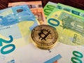 Golden bitcoins stacked on each other on different euro paper money as a new way of foreign and global trading, investing in