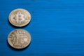 Golden bitcoins on a textured blue wooden background