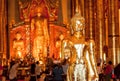 Golden body of Buddha inside the rich Thai temple with crowd of tourists Royalty Free Stock Photo