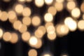 Golden bokeh on a black background, abstract dark backdrop with defocused warm lights Royalty Free Stock Photo