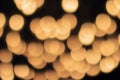 Golden bokeh on a black background, abstract dark backdrop with defocused warm lights Royalty Free Stock Photo