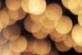 Golden bokeh on a black background, abstract dark backdrop with defocused warm lights Royalty Free Stock Photo