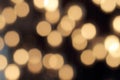 Golden bokeh on a black background, abstract dark backdrop with defocused warm lights Royalty Free Stock Photo