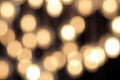 Golden bokeh on a black background, abstract dark backdrop with defocused warm lights Royalty Free Stock Photo