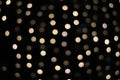 Golden bokeh on a black background, blurred lights