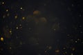 Golden bokeh lights sparkles of glitter dust particles dark abstract overlay