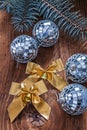 golden bows and christmas disco balls with pinetree branch on old wooden board