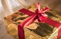 Golden box of present with red ribbon Royalty Free Stock Photo