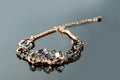 Golden bracelet with precious stones on grey Royalty Free Stock Photo