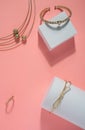 Golden bracelets and Necklace and ring set on pink and white background