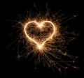 Golden bright sparkler heart shape love shaped symbol isolated dark black background. silvester new year birthday wedding and