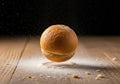Golden brown bread roll appears to float above a wooden surface, surrounded by flour particles Royalty Free Stock Photo