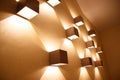 Golden brown bronze color cube shaped sconces on a wall. Geometry in design concept Royalty Free Stock Photo