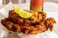 Golden brown conch fritters with sliced lime on top.