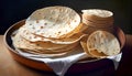 Golden-brown flatbreads stacked on a dark background, with hints of char marks and steam rising from the freshly cooked bread,