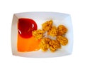 Golden brown fried chicken in small pieces on square white paper plate with Tomato ketchup and chili sauce isolated on white backg Royalty Free Stock Photo