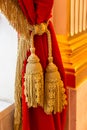 Golden brush on a red velvet curtain Royalty Free Stock Photo