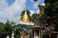 Golden Buddha image, sacred belief in Thai temple located on high mountain, forest and sky background.