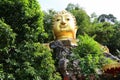 Golden Buddha image, sacred belief in Thai temple located on high mountain, forest and sky background.