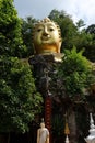 Golden Buddha image, sacred belief in Thai temple located on high mountain, forest and sky background.