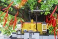 Golden Buddha sculpture with red Chinese talisman