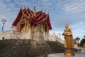 Golden Buddha standing holding an alms bowl at Wat Pa Phu Hai Long