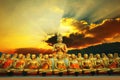 golden buddha statue in buddhism temple thailand against dramatic sun rising with ray beam background Royalty Free Stock Photo