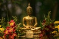 Golden buddha statue flanking with flowers