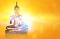 Golden Buddha statue with glittering aura on a golden yellow background for design and a beautiful background. Royalty Free Stock Photo