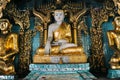 Golden Buddha statue in temple at Shwedagon Pagoda in Yangon.