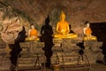 Golden buddha statues along the wall inside the cave