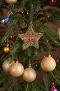 Golden bulbs and star on christmas tree close up Royalty Free Stock Photo