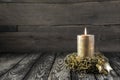 Golden burning advent candle on wooden nostalgic background.