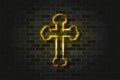 Golden Byzantine cross glowing neon sign or glass tube on a black brick wall. Realistic vector art Royalty Free Stock Photo