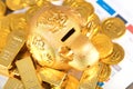 Golden calf piggy bank on gold coins and bars