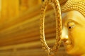 golden calm face of Buddha statue with golden background.