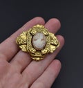 golden cameo brooch on a woman's hand, old retro jewelry Royalty Free Stock Photo