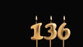 Golden candle 136 with flame - Birthday card on dark luxury background