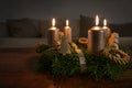 Golden candles on an advent wreath with some natural Christmas decoration on a wooden coffee table in the living room, copy space Royalty Free Stock Photo