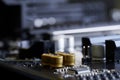 Golden capacitors built into the black motherboard of a modern computer. Photo. Macro Shallow depth of field. Selective focus Royalty Free Stock Photo