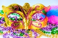 Golden carnival mask and colorful beads close-up. Mardi Gras or Fat Tuesday symbol. Royalty Free Stock Photo