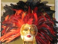 Golden carnival mask for festivals and performances with blue and red feathers around it Royalty Free Stock Photo