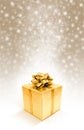 Golden celebration gift box on sparkle snow background