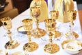 Golden chalices on the altar on top of a white table top Royalty Free Stock Photo