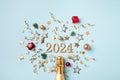 2024 champagne bottle christmas and New Year composition with fir tree, party streamers, confetti stars and decorations. Flat lay Royalty Free Stock Photo